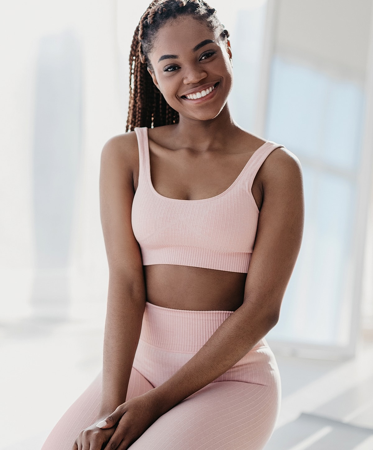 Smiling woman in pink athletic wear indoors.