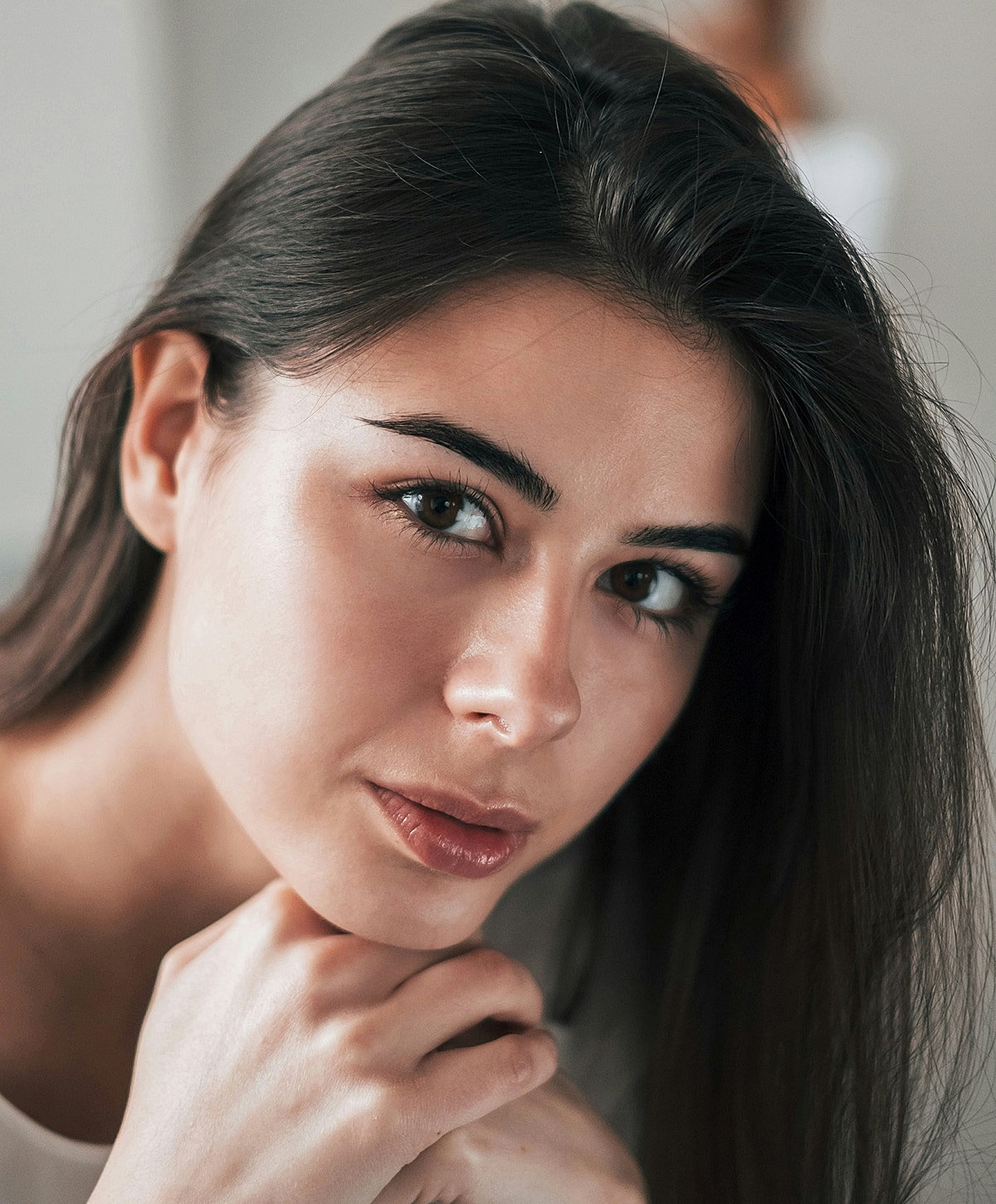 Young woman with long hair, thoughtful expression.