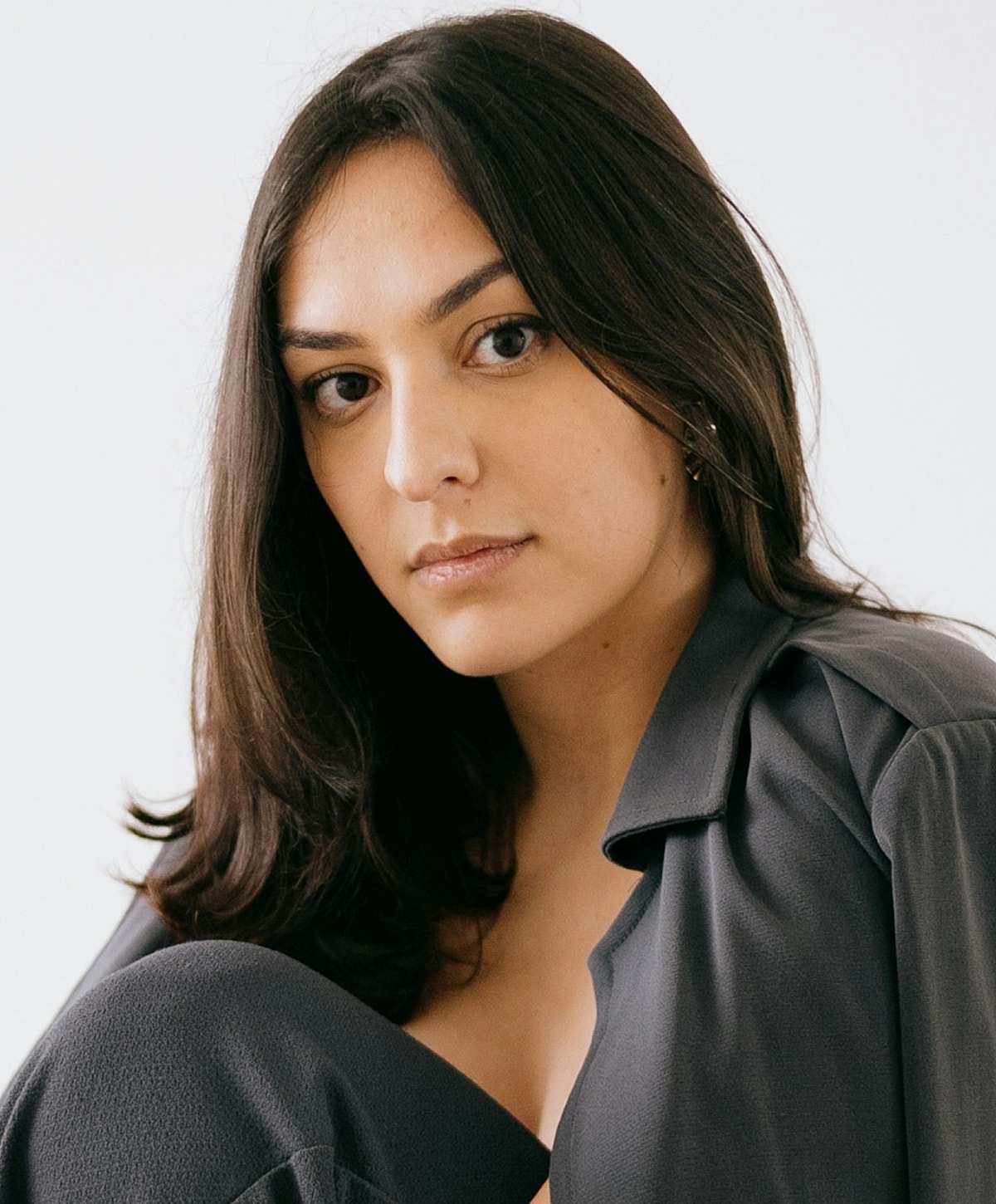Smiling woman in white lingerie on light background.