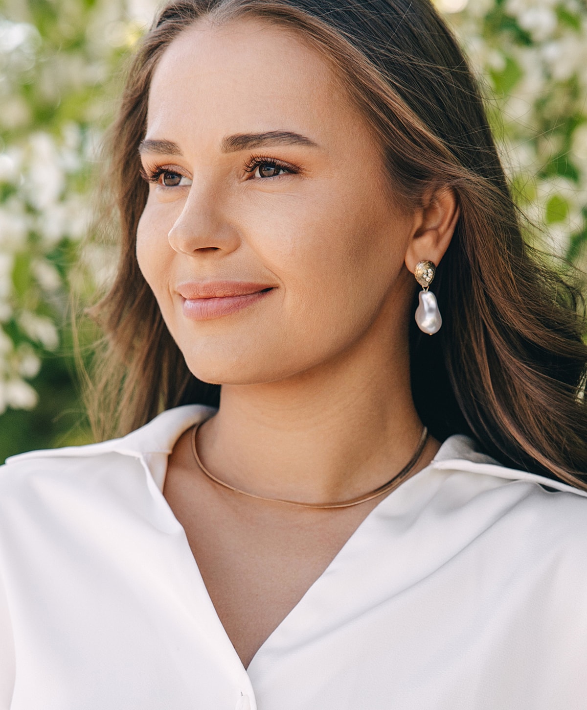 Woman showcasing elegant jewelry and fashion.