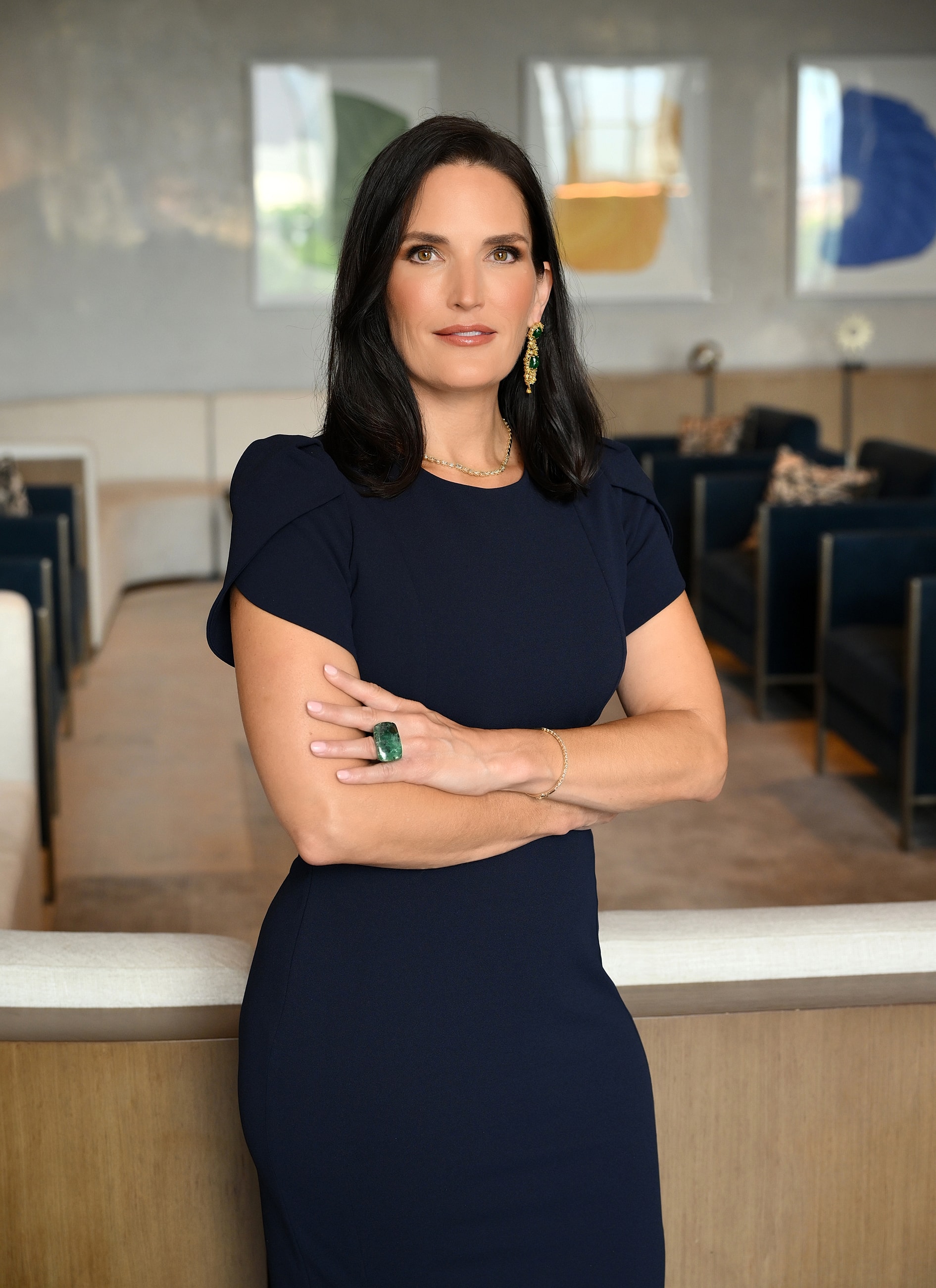 Woman in elegant dress, confidently posing indoors.