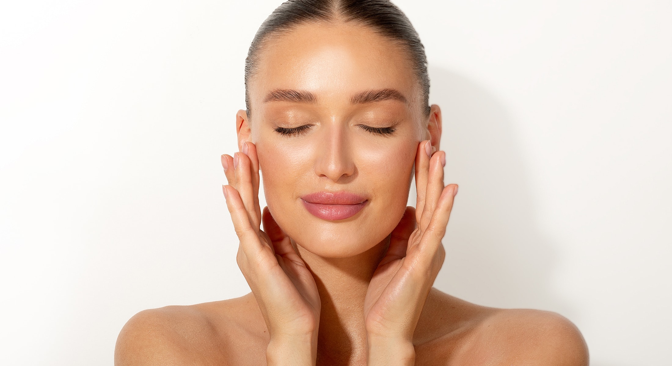 Woman with closed eyes touching her face.