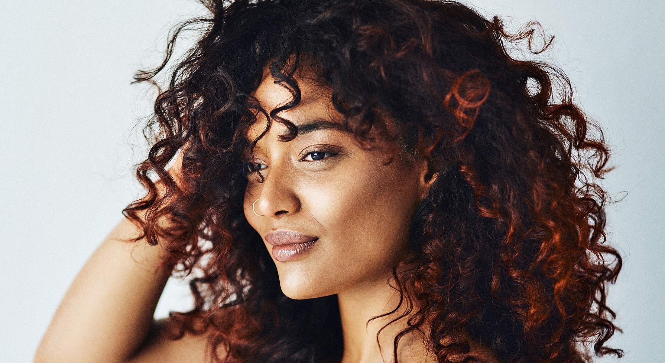 Woman with curly hair and confident expression.