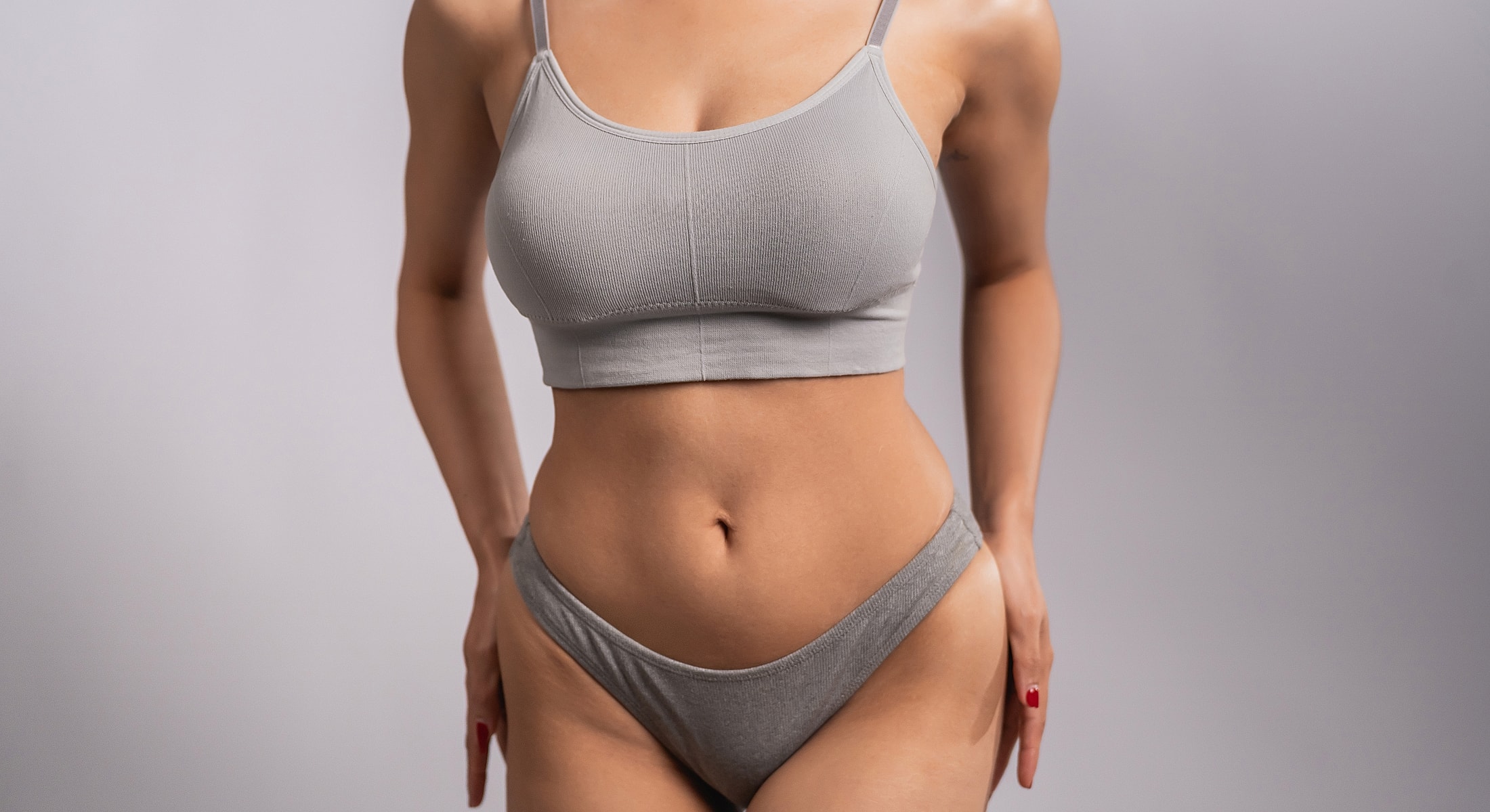 Model in gray lingerie posing confidently.